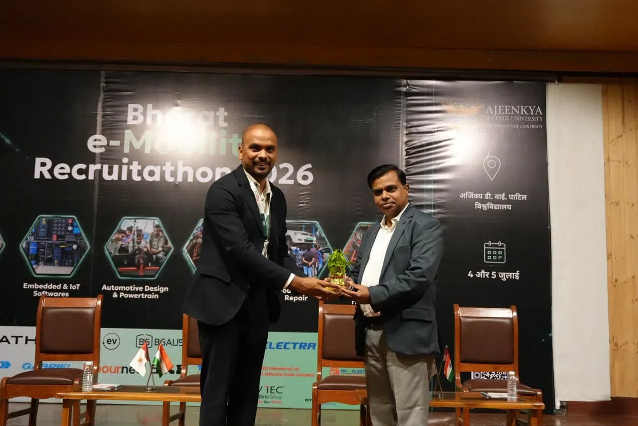 A guest being presented with a memento on stage in front of the Recruitathon backdrop